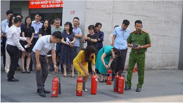 Các học viên thực hành sử dụng bình bột, bình khí CO2 để dập tắt đám cháy giả định